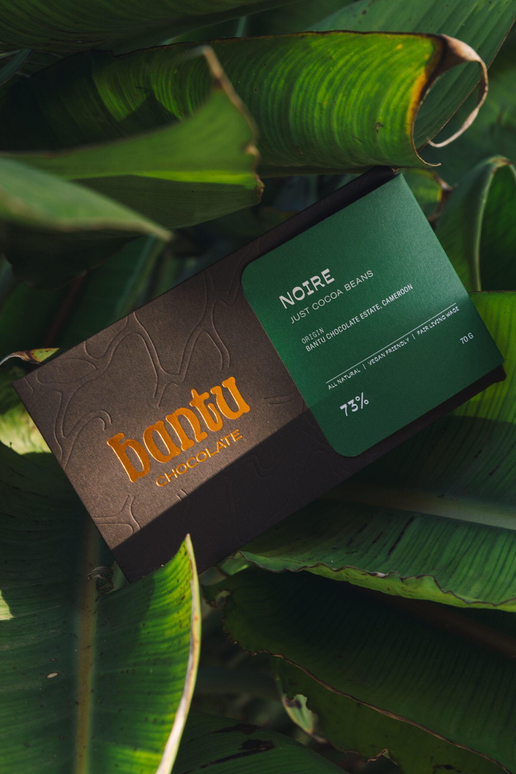 Noire 73% Bantu Chocolate label lying on plaintain leaves
